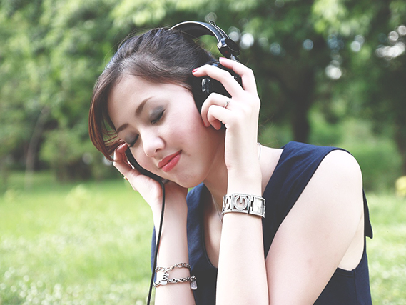 person outside holding headphones to their ears