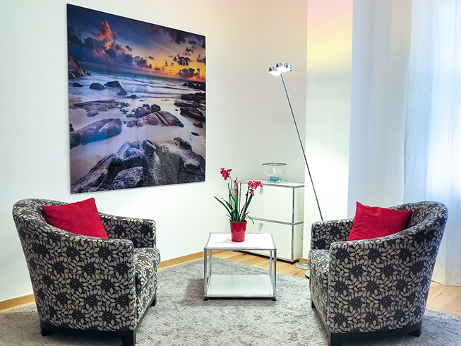 room with two chairs, table plant, wall art, floor lamp