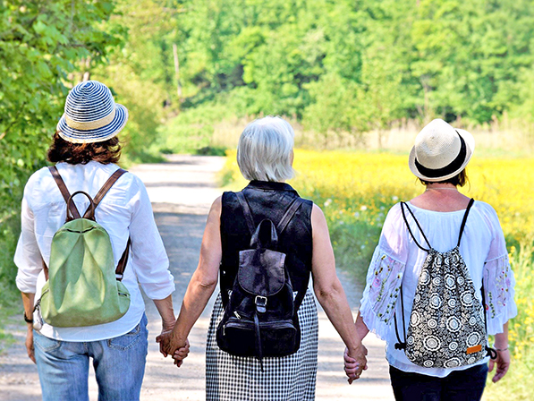 three adults walking and holding hands