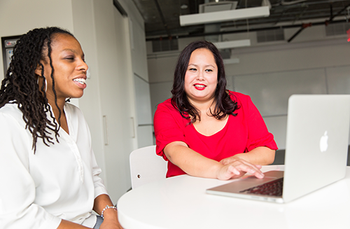 Two women smiling with laptop