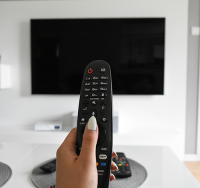woman-turning-on-tv-with-remote