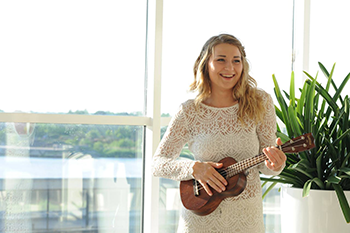 woman in wedding dress playing ukulele