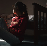 woman sitting next to her bed