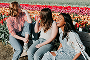 three girls laughing in a tulip field