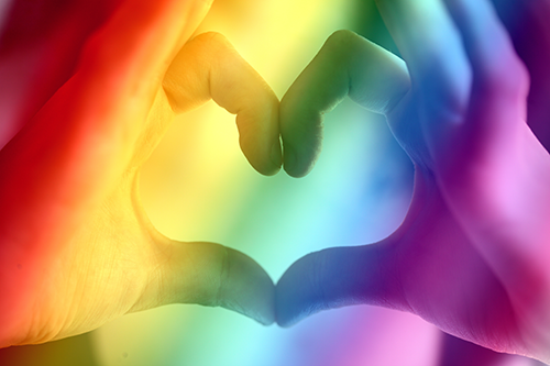 Hands in shape of heart with rainbow 