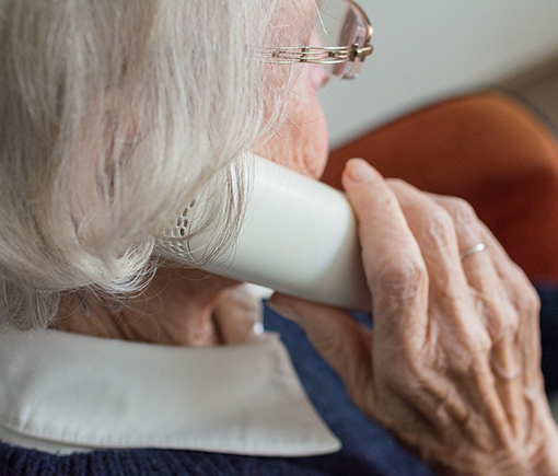 older adult holding phone to right ear