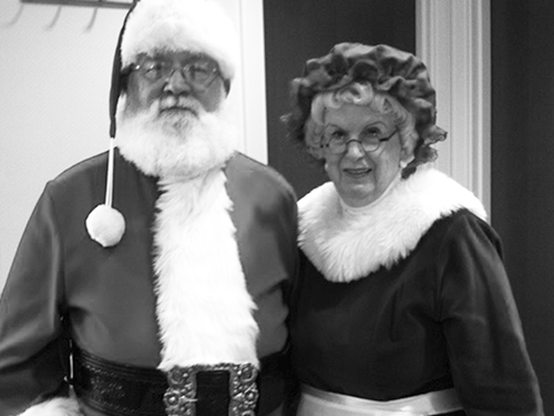 Bonnie dressed as Mrs. Claus and standing next to Santa Claus