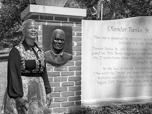 Carolyn Banks standing next to entrance sign