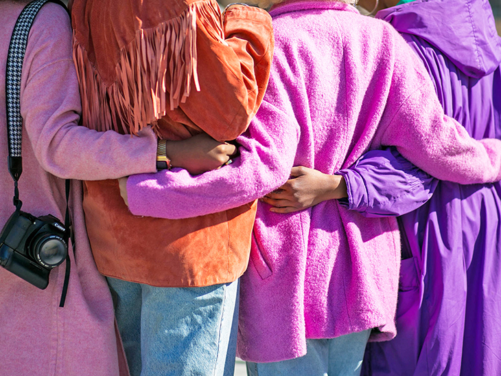 four people  hugging side by side