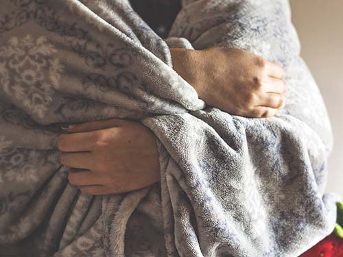 hands wrapped inside blanket