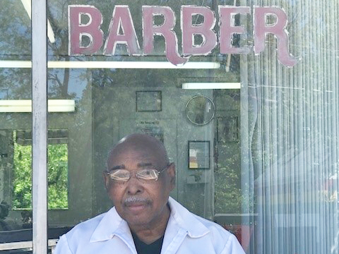 Herman "Smitty" Smith sitting in front of store front