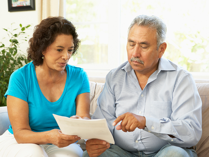 older couple sitting looking at document
