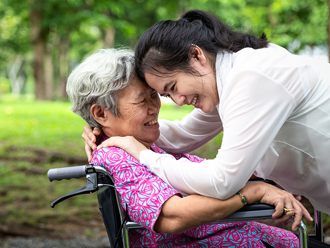 older adult hugging parent outside