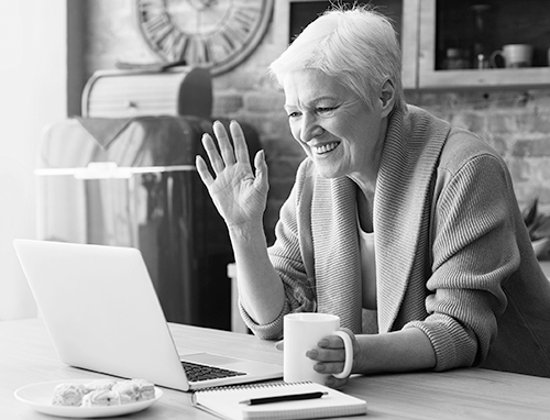 older adult waving at laptop screen