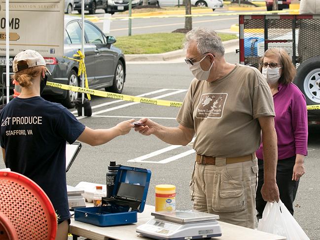 people exchanging payment at farmers market