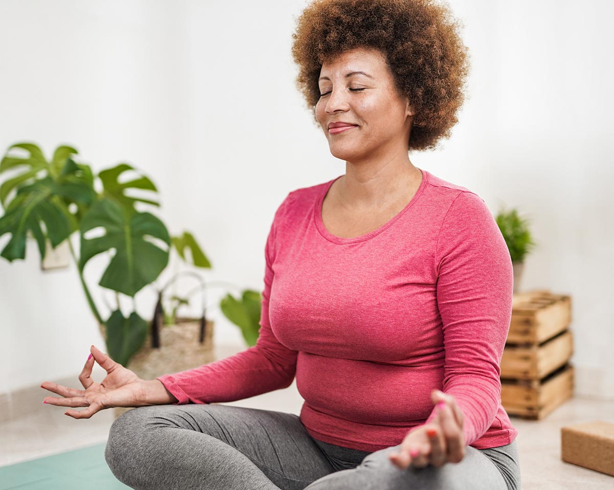 Woman sitting on a yoga mat practicing mindfulness.