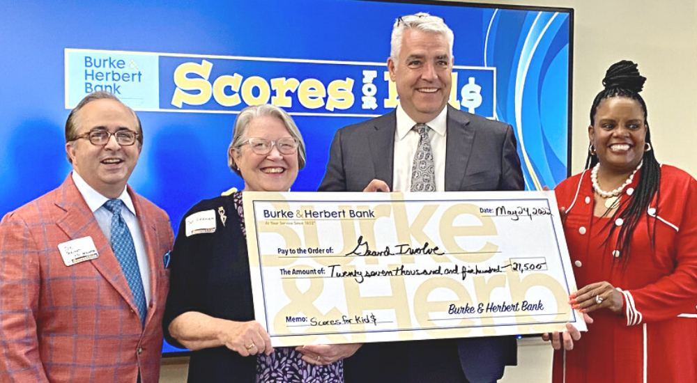 Photo of Burke & Herbert president David Boyle presenting a large check to GrandInvolve founder Dorothy Keenan.