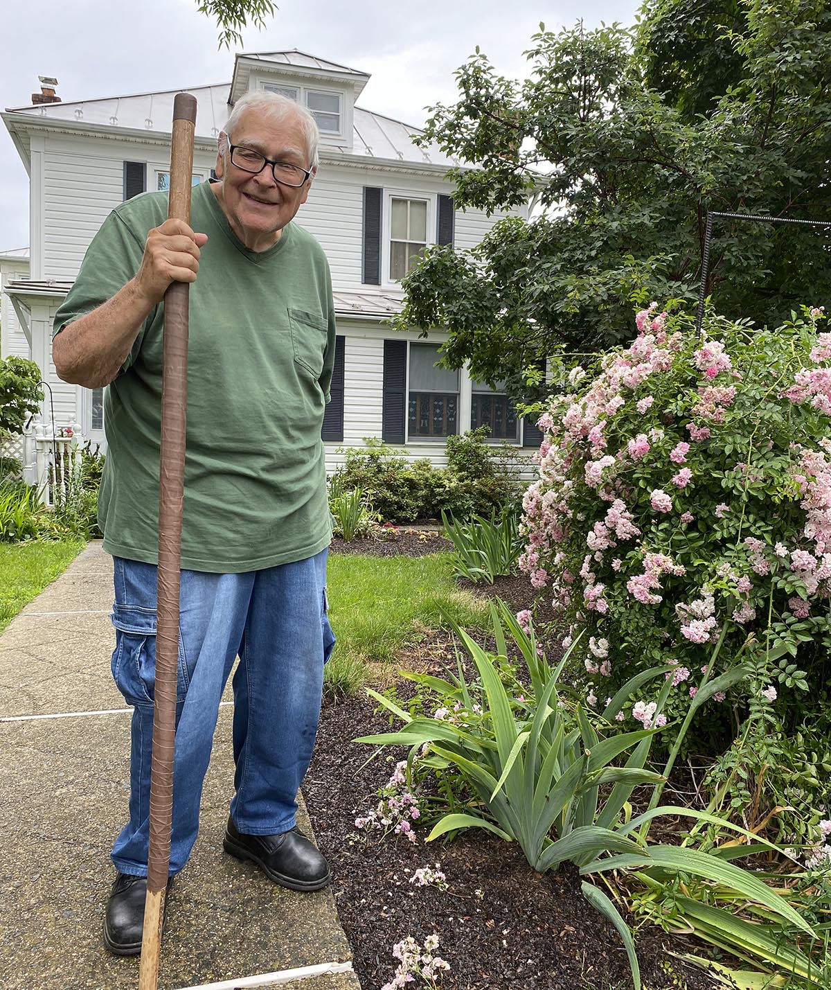 Photo of Master Gardener Joe Francis standing in front of his home.