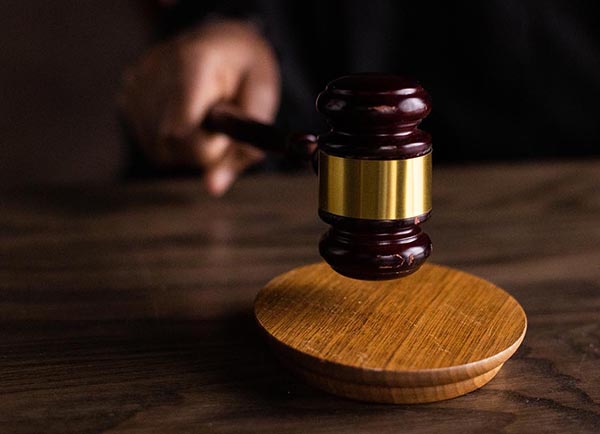 Photo of a hand banging a gavel on a desk