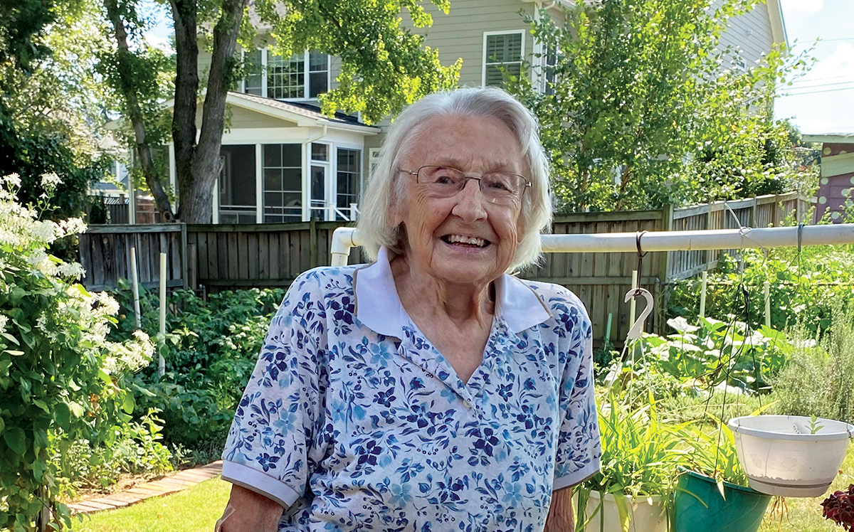 Photo of Mary Ann McKenzie standing in her backyard.