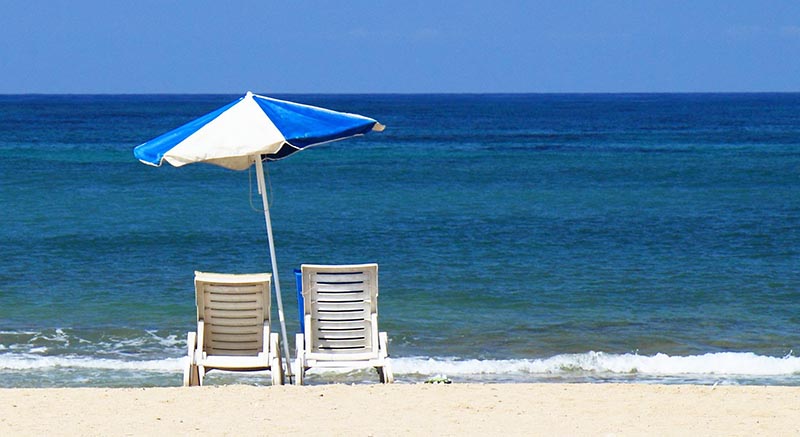 Photo of chairs and an umbrella on a beach