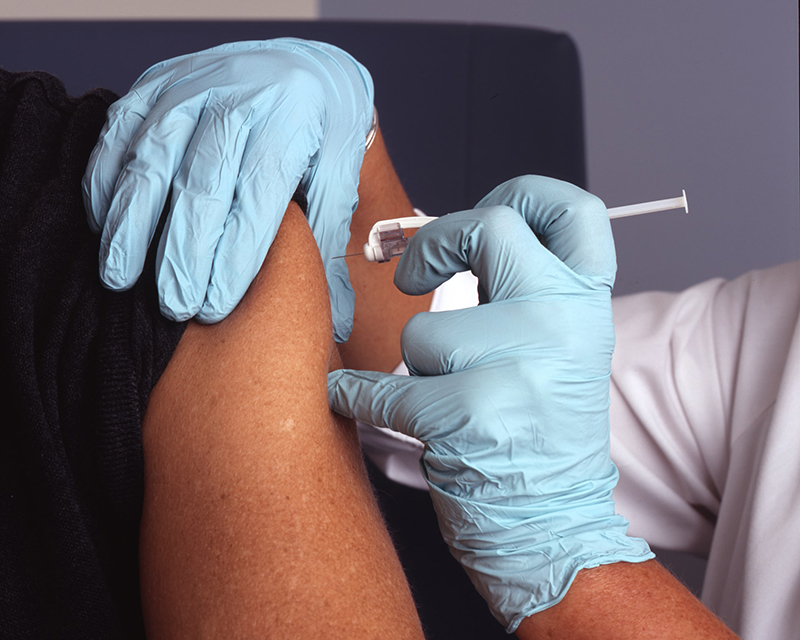 Photo of a person getting a flu shot or other vaccine.