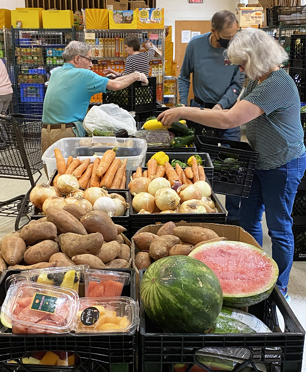 Volunteers sort vegetables to prepare them for handing out. 