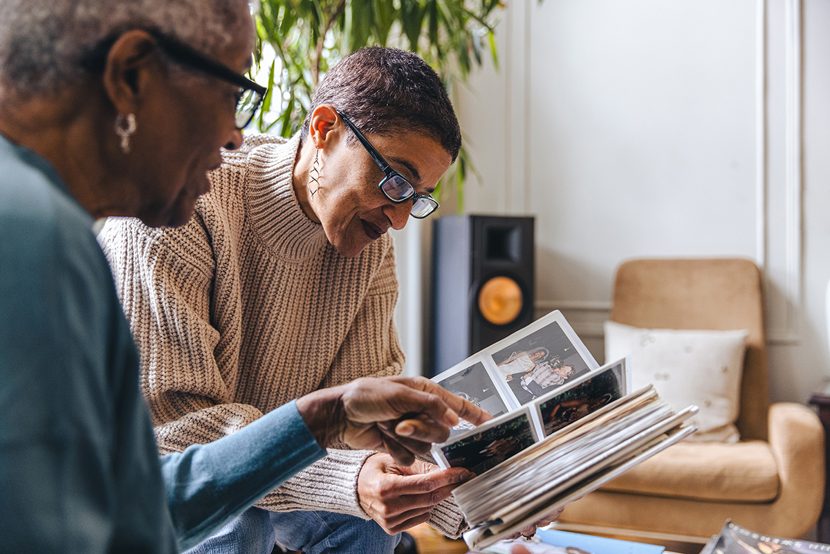 Photo of two women looking at a photo album together.