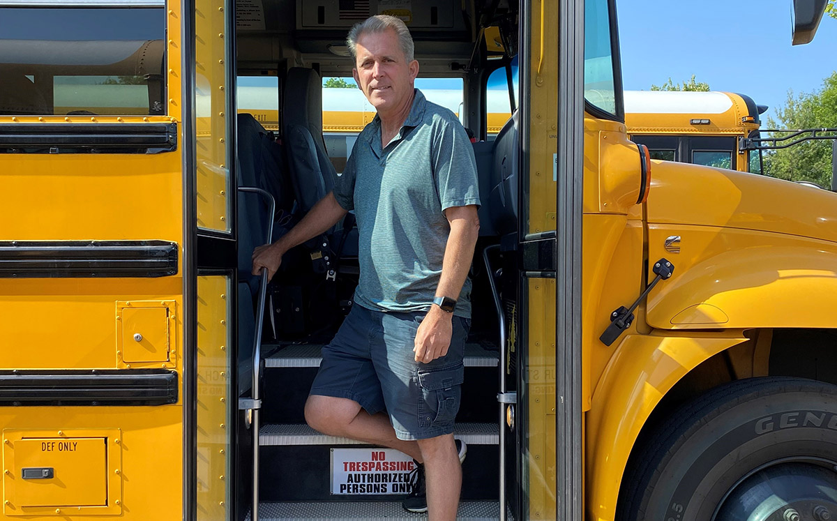 Jay Corwin standing in the doorway of his school bus.