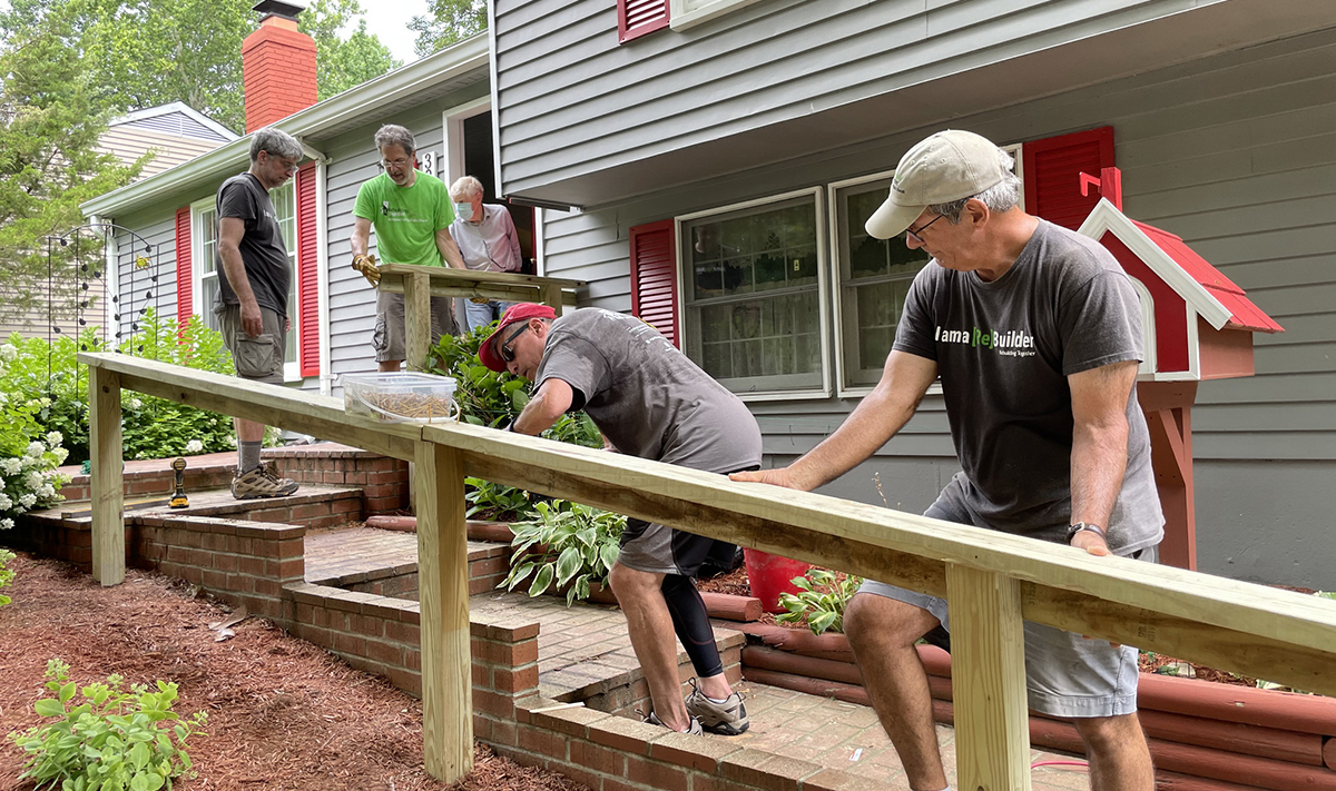 Photo of Rebuilding Together-AFF volunteers installing a handrail outside the home of an older adult.