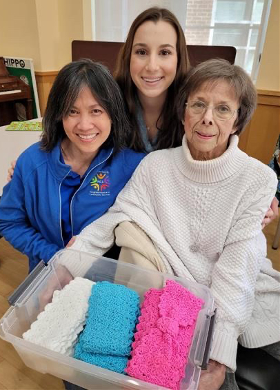 Photo of NCS staff and participants with items they knit or crocheted for their Winter Warming Service Project.