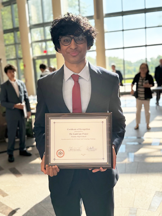 Photo of Advik Atyam holding the plaque he received as winner of the 2024 Shark Tank Challenge.
