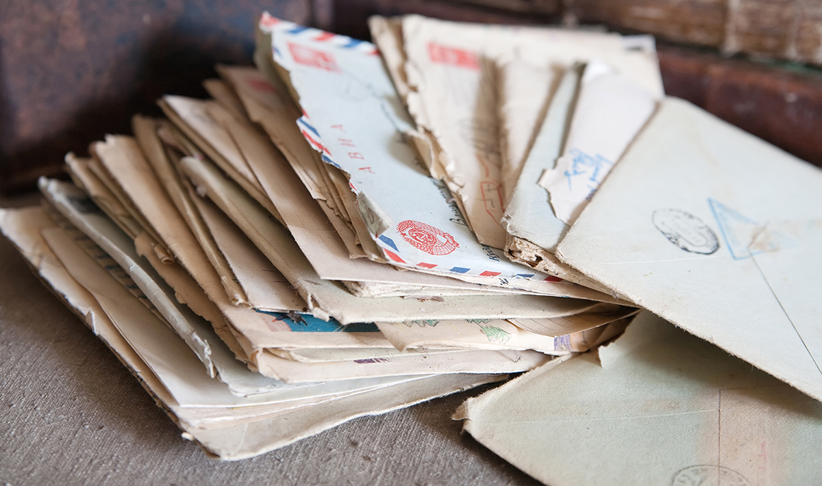 Photo of a stack of old letters fanned out on a surface.