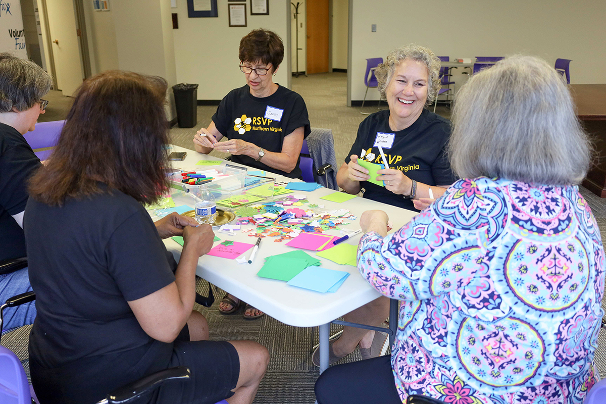 Photo of RSVP-NV volunteers gathered at a table working together.