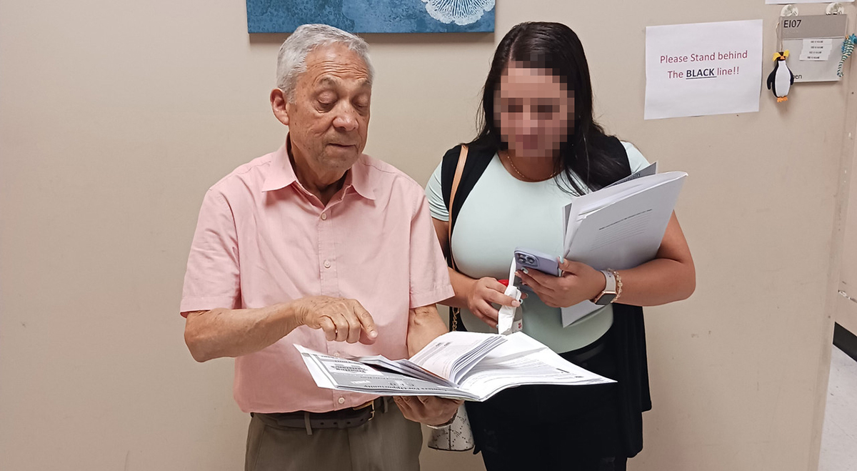 Mr. G pictured showing employment materials to a VCW client. 