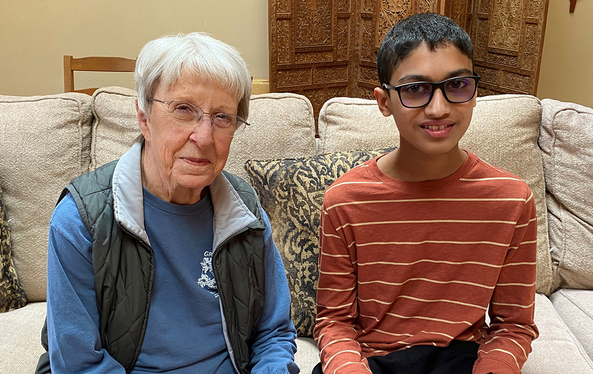 Photo of Susan Voss and Jonathan D'Cruz seated on a sofa in Susan's living room.