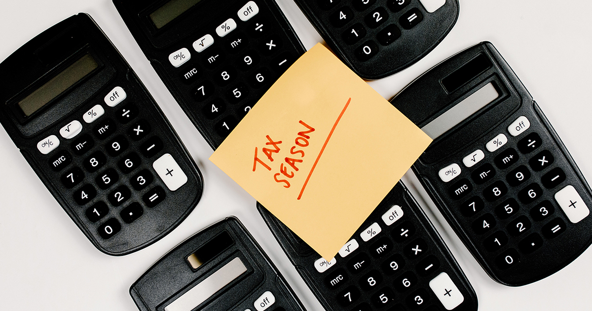 Photo of six calculators with a post-it not sitting on top. Tax Season is written on the note.