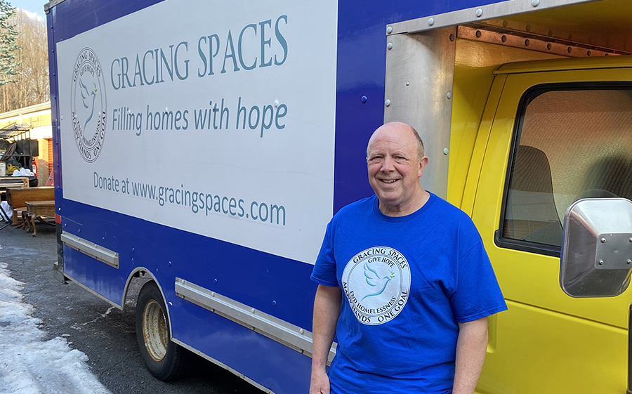 Scott Daniels stands next to the passenger door of the Gracing Spaces box truck. 