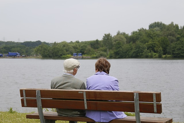 older man and woman sitting on bench
