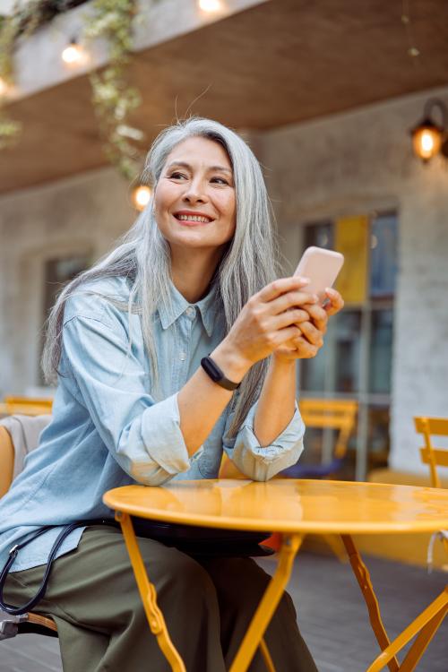 Woman with silver hair holding a cellphone
