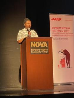 Woman speaks at podium on stage. 
