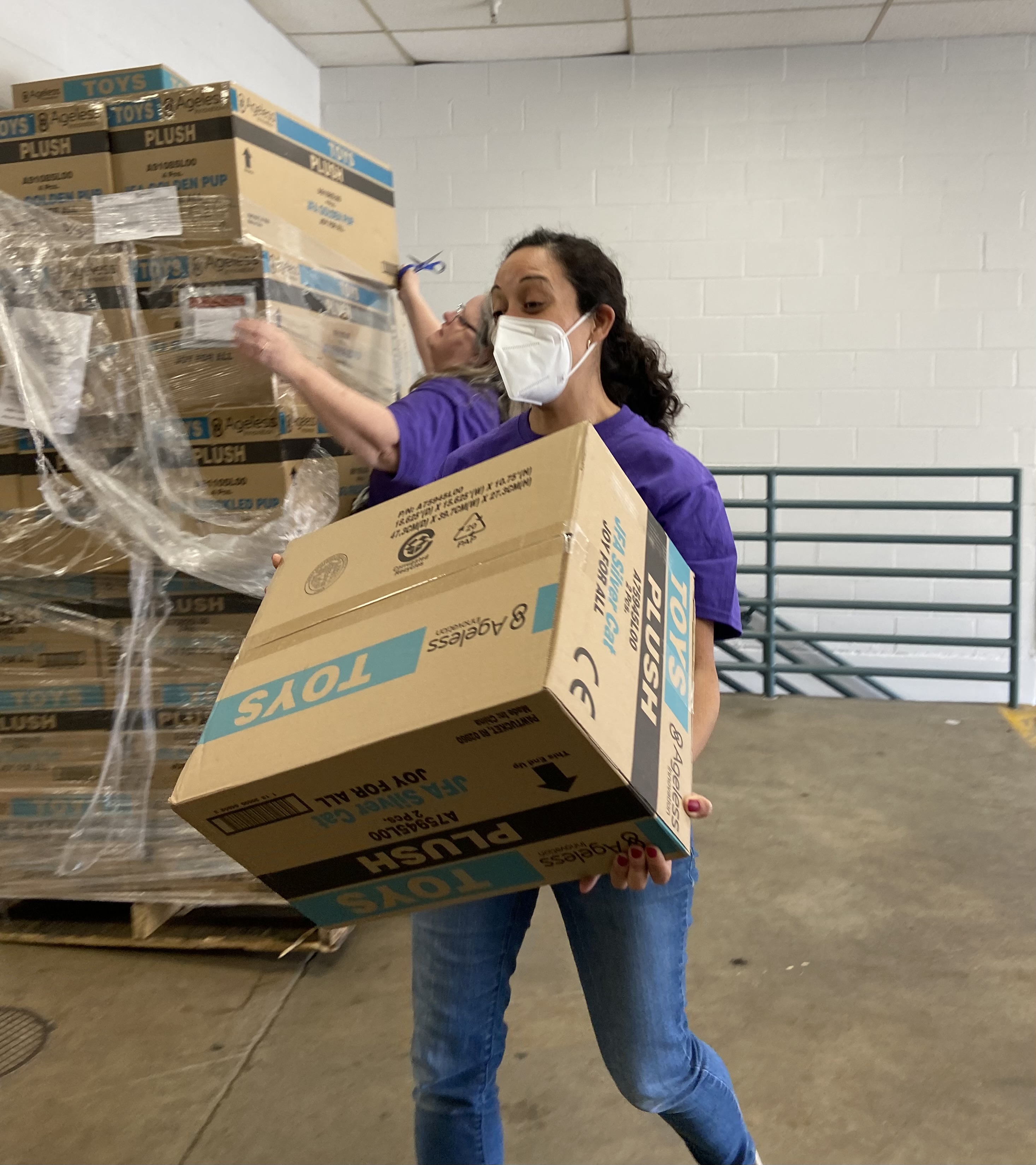 Volunteer Solutions staff unload boxes of robotic pets