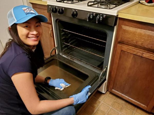 Volunteer cleaning a stove. 