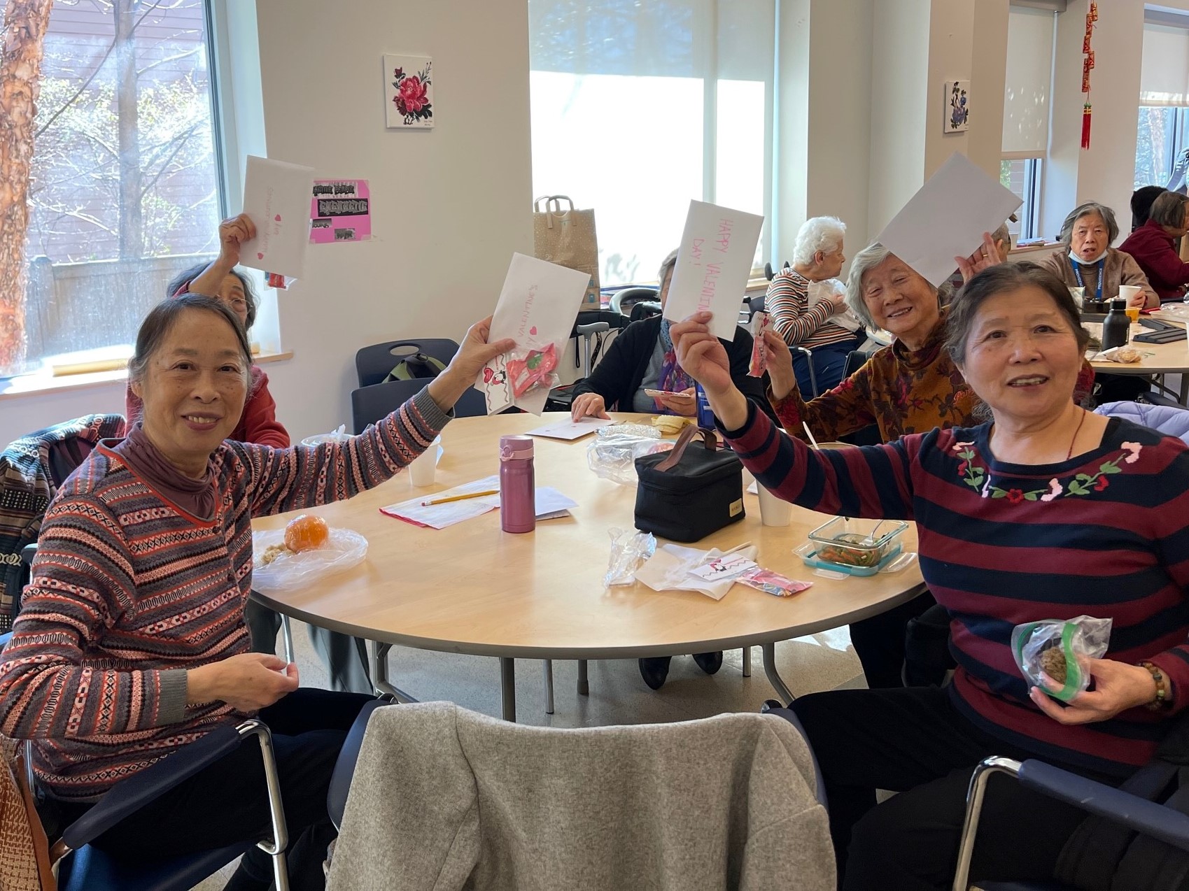 group of ladies smiling holding valentine's day cards