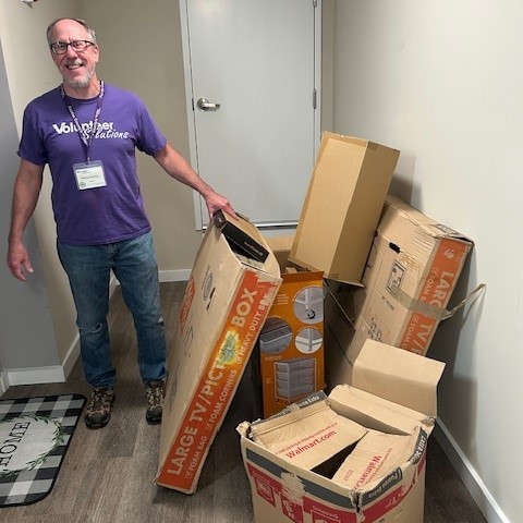 man standing next to boxes