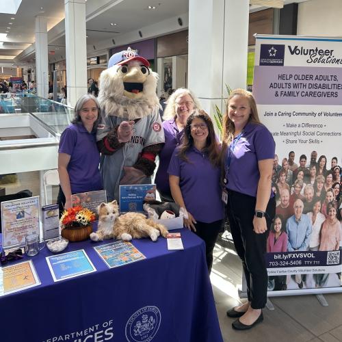 Volunteer Solutions staff and Screech at the table