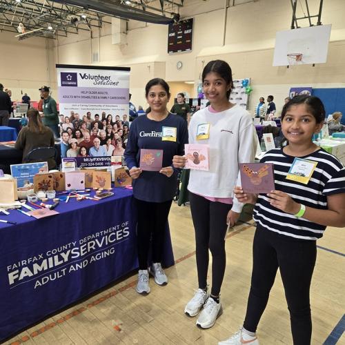 mother and daughters holding cards