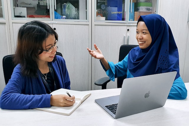 Two women smiling with laptop