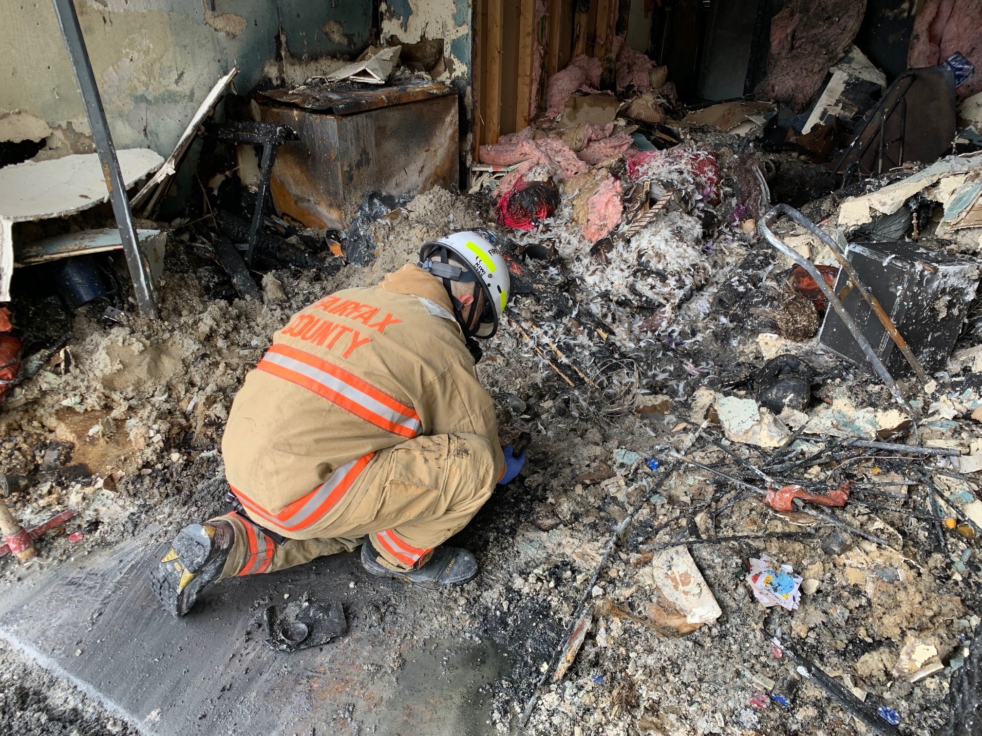 Fireman looking through ashes