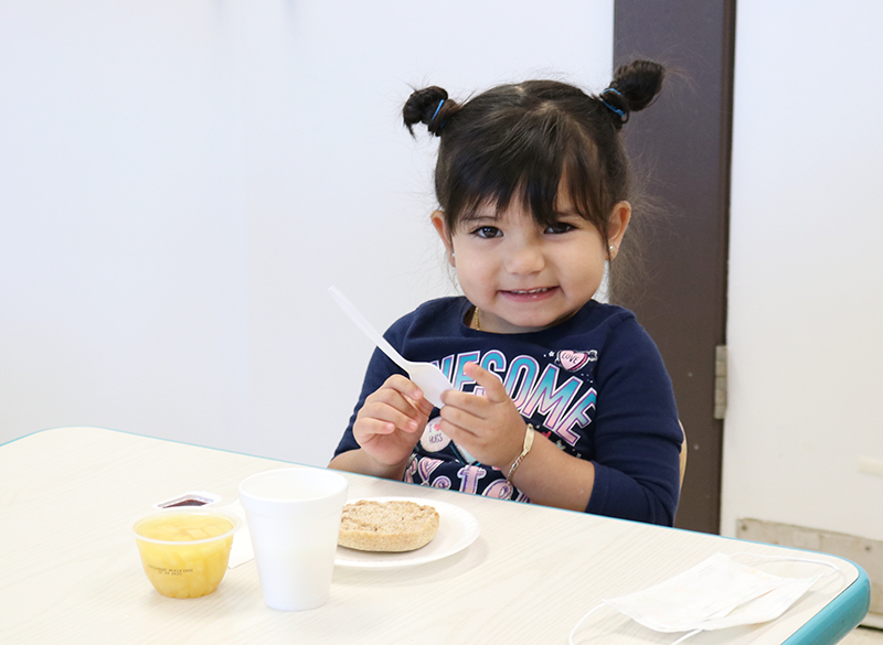 Little girl at table with food